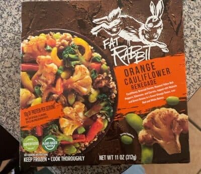 Orange Cauliflower Renegade, Broccoli Florets, Roasted Yellow Bell Peppers, Edamame, And Carrots, Topped With Walnuts And Green Onions In A Sweet Orange Sauce, Over Red And White Quinoa